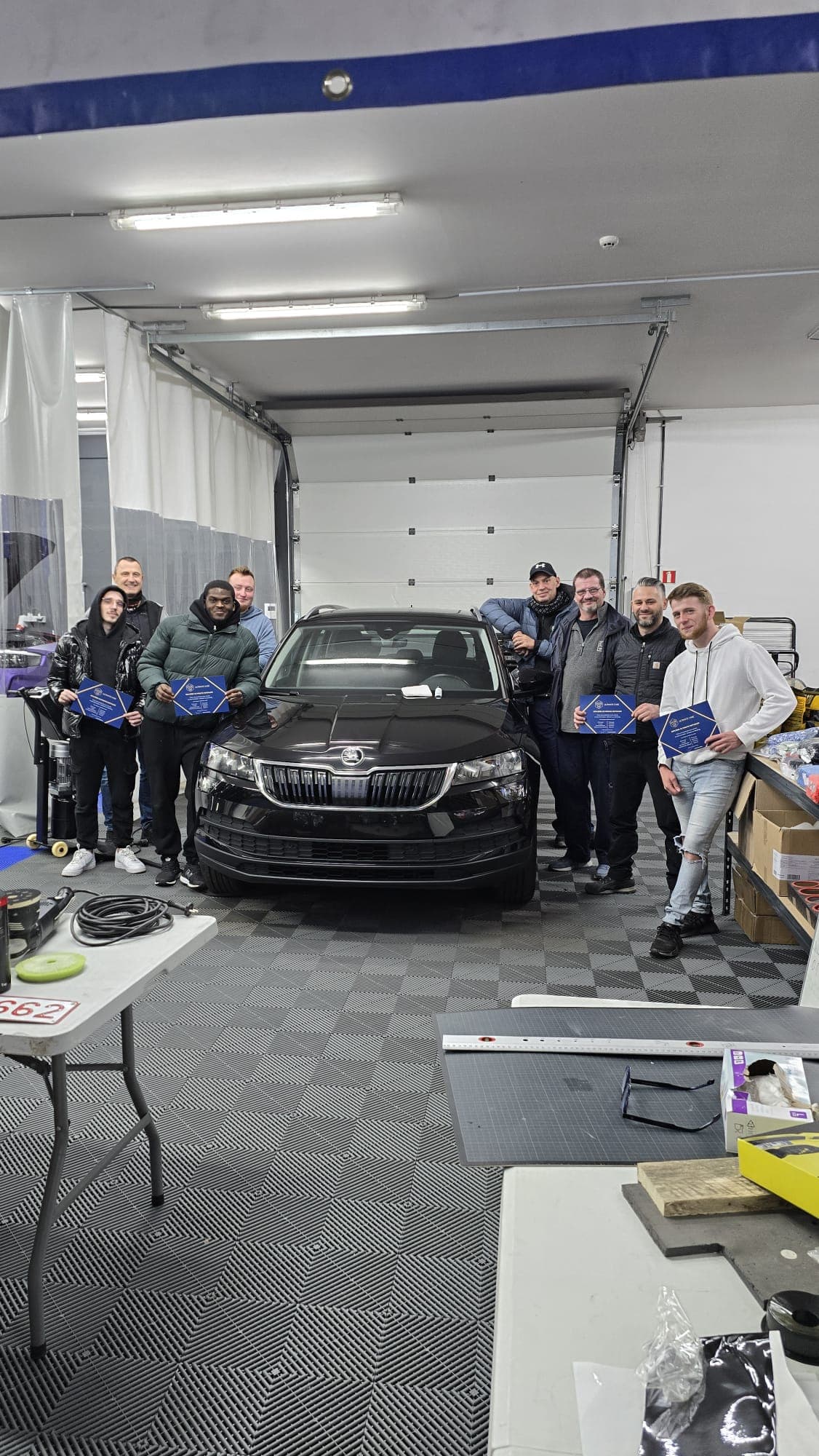 Equipe Ultimate Care autour d'un vehicule dans l'atelier